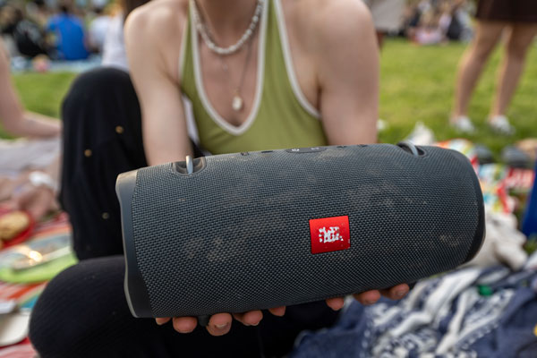 Eine Person hält eine JBL Musikbox in den Händen.