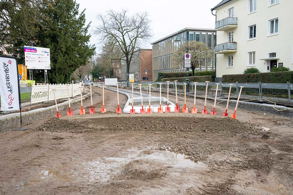 Straßenbaustelle mit zahlreichen Spaten für Spatenstich