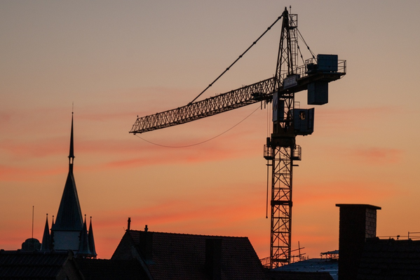 Bauturbo Baustellenkran bei Sonnenuntergang mit Freiburg Panorama im Hintergrund