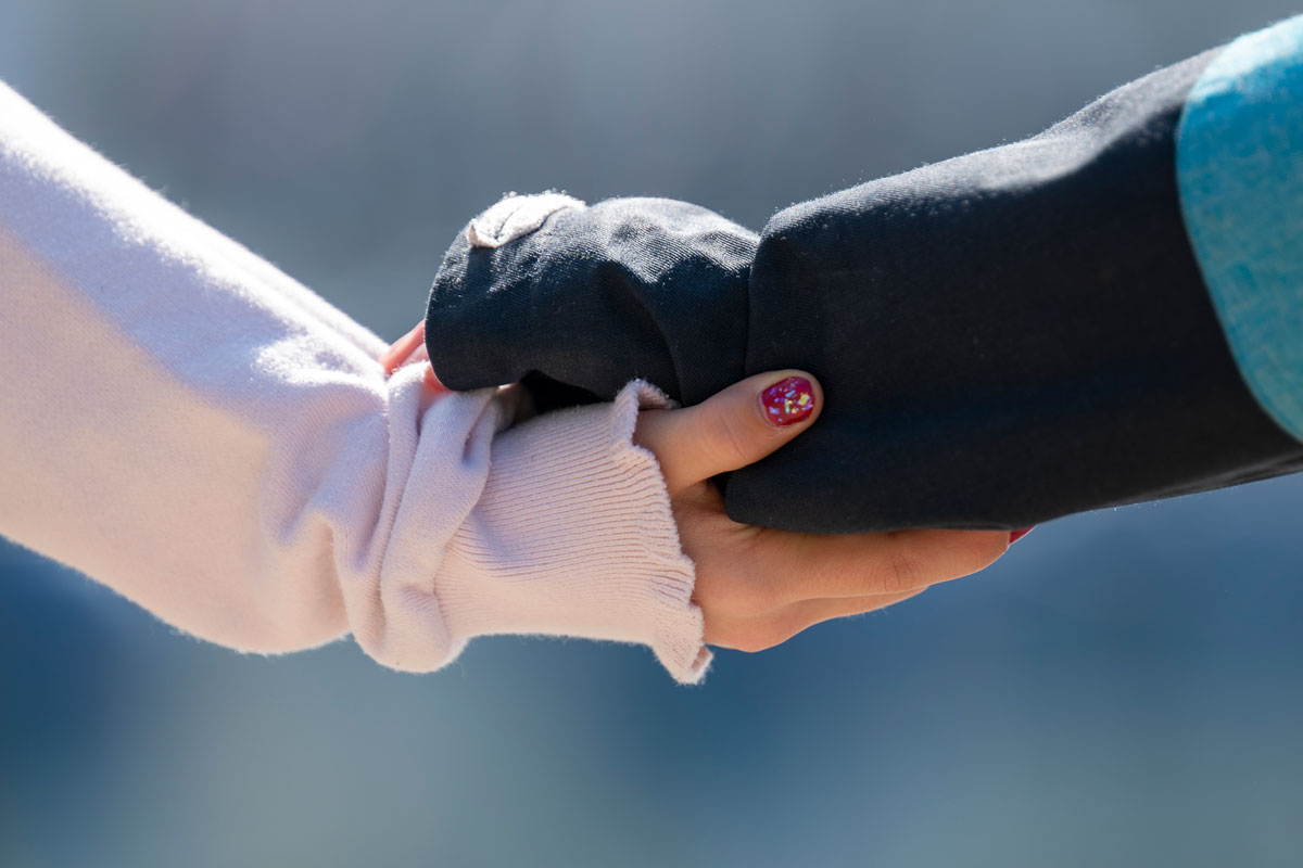 Zwei Personen halten/geben sich die Hand