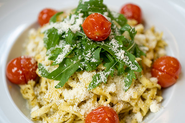 Nudeln mit Soße und Tomaten und Rucola und Käse