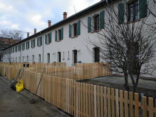 Reihenhauszeile mit vorgarten und Zaun nach der Sanierung