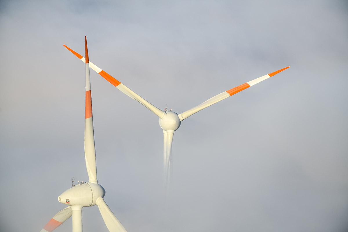 Zwei Windkraftrotoren im Nebel