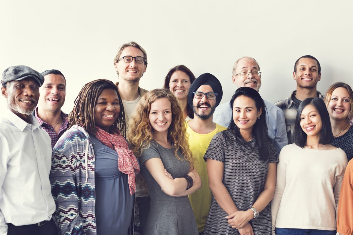 Eine diverse Gruppe von Menschen posiert für ein Gruppenfoto.