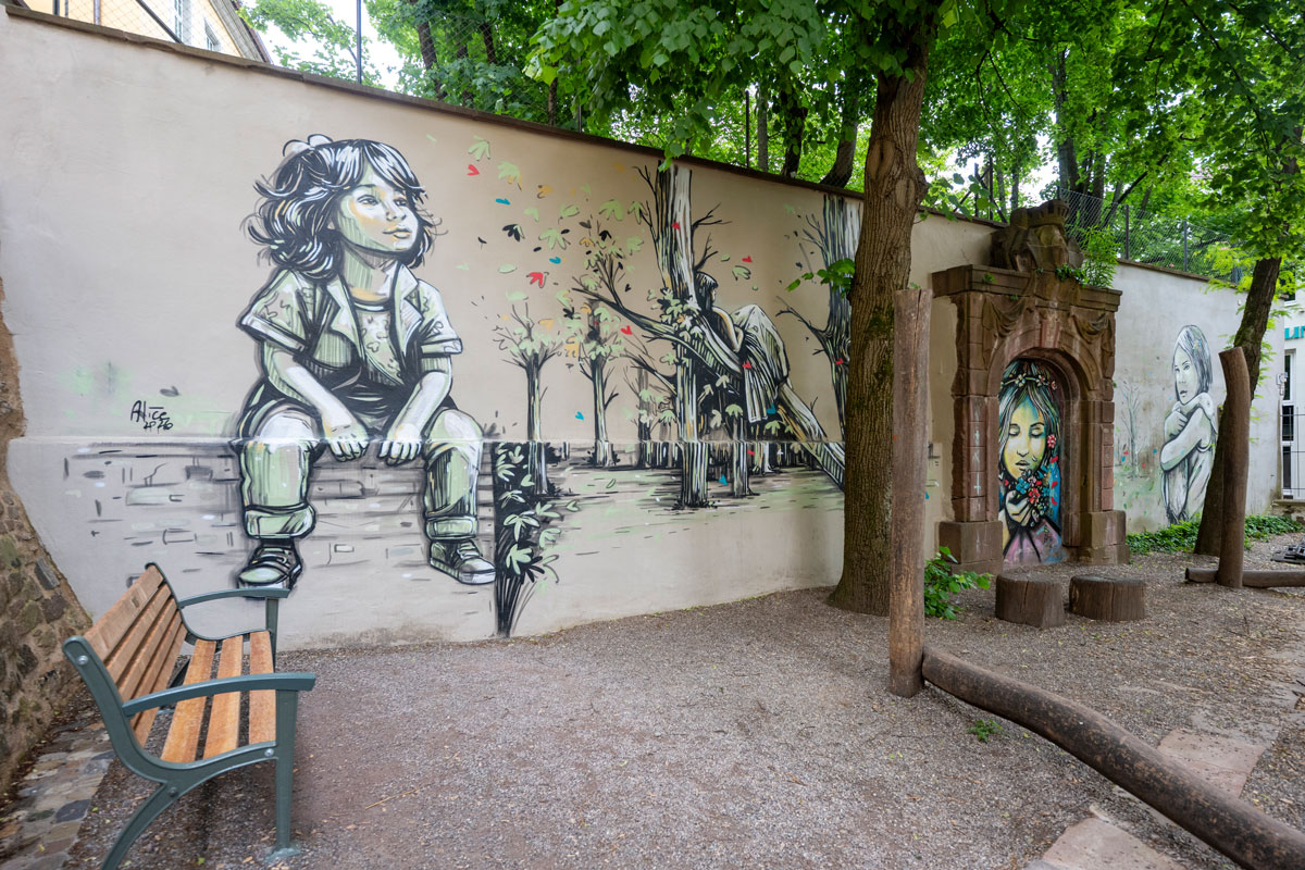 Mit Streetart bemalte Mauer an einem Spielplatz
