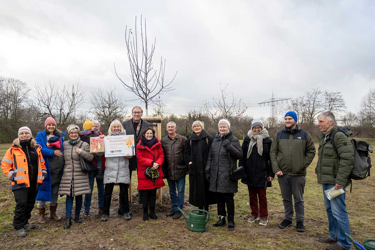 Gruppe von Menschen vor einem herbstlichen Obstbaum