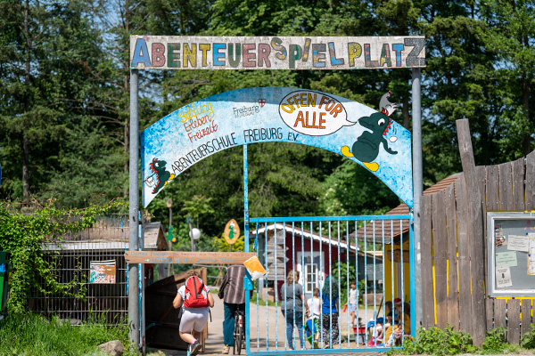 Eingangstor mit der Aufschrift "Abenteuerspielplatz. Offen für alle"