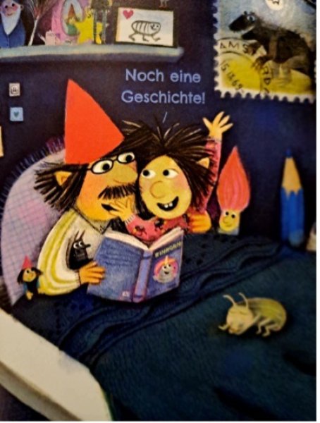 Papa und Sohn lesen im Bett eine Geschichte.