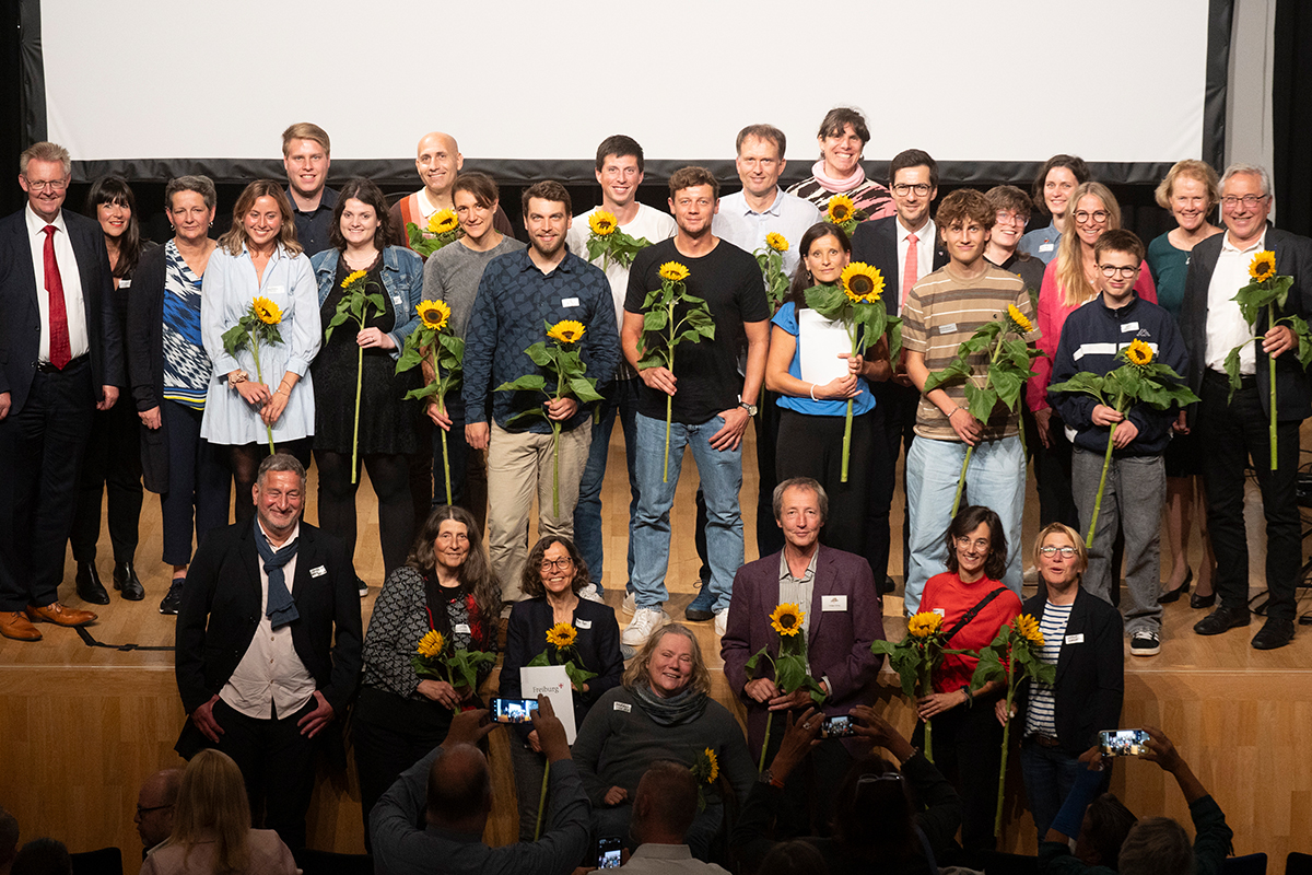 Gruppenfoto der Geehrten, viele halten Sonnenblumen in der Hand.