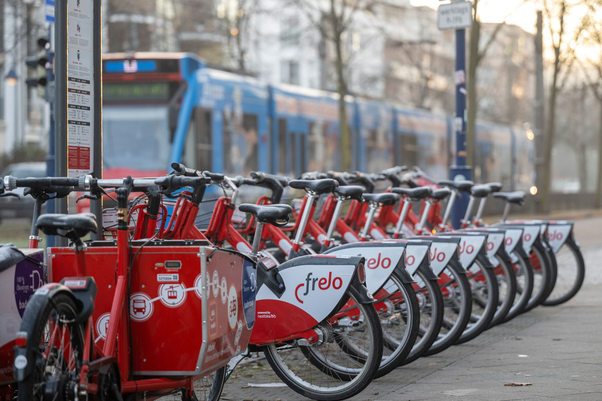 Reihe mit rot-weißen Leihfahrrädern am Straßenrand