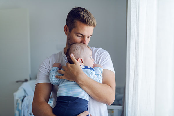 Ein Mann hält ein Baby im Arm