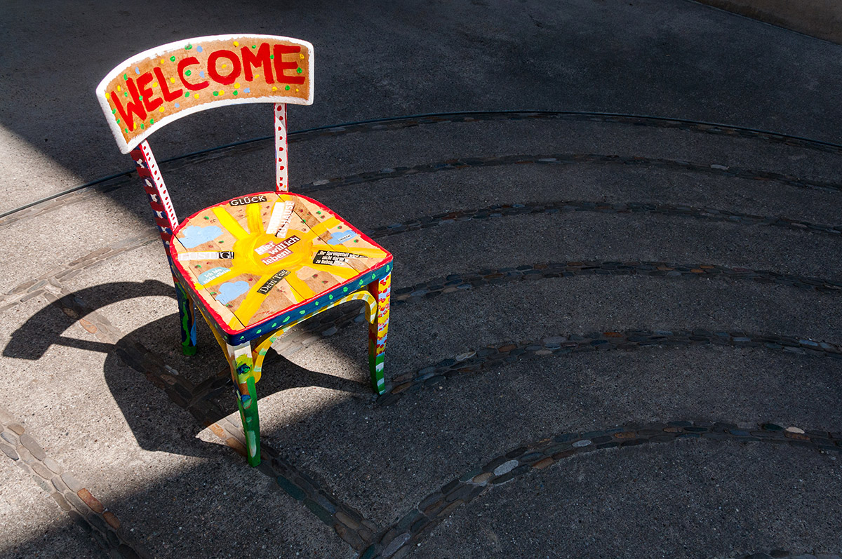 Bunter Stuhl mit "Welcome" auf Platz