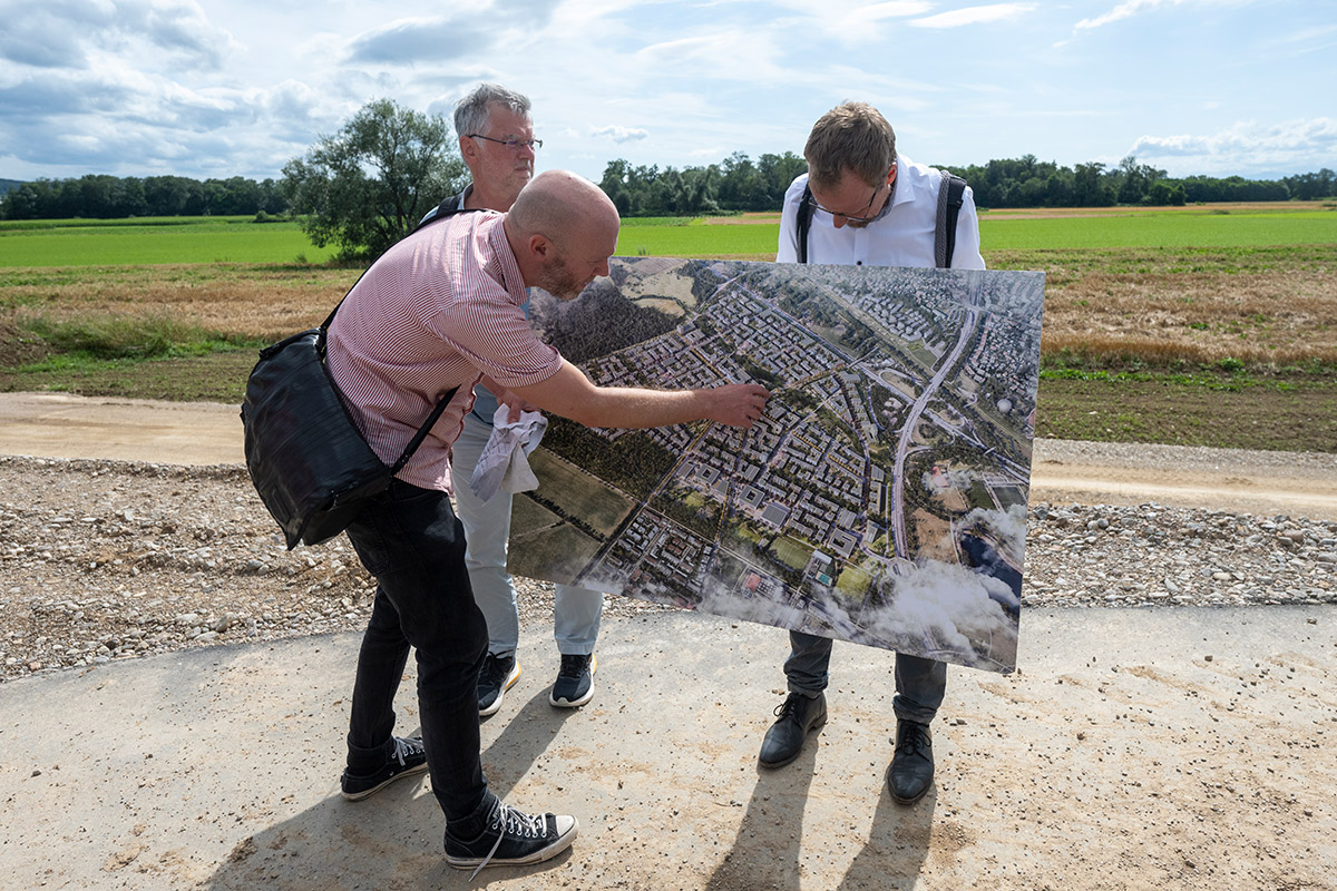 Drei Menschen um einen Plan vom Stadtteil Rieselfeld