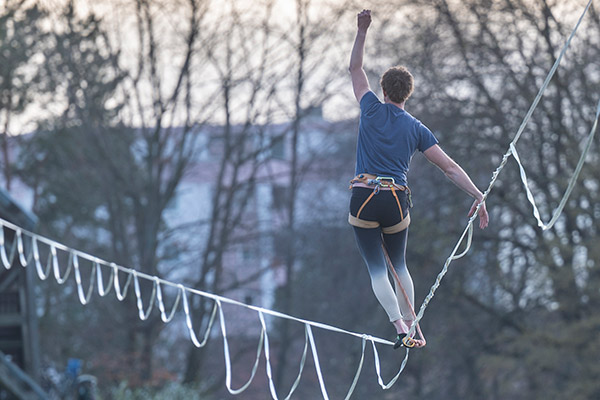 Mann von hinten auf Slackline