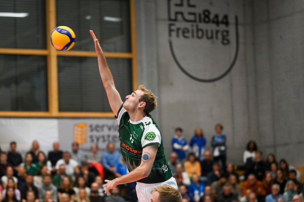 Volleyballer vor FT-Freiburg-Logo