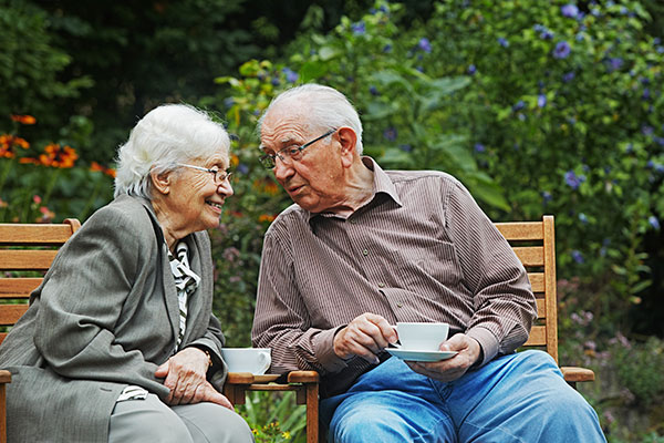 Seniorin und Senior beim Kaffeetrinken im Garten