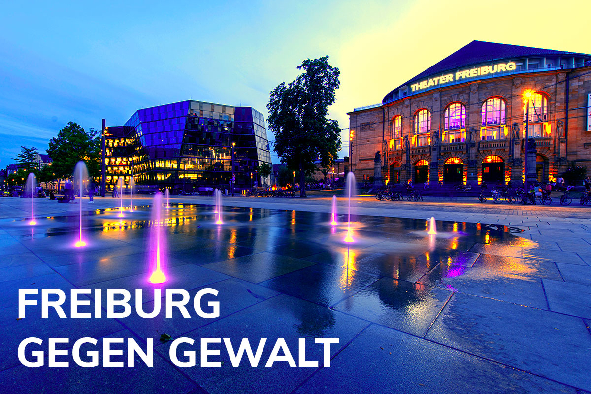 Schriftzug: Freiburg gegen Gewalt auf Foto vom Platz der Alten Synagoge mit Theater undund Unibibliothek