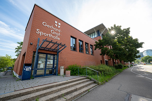 Schriftzug "Sporthalle" auf Gebäude vor Himmel