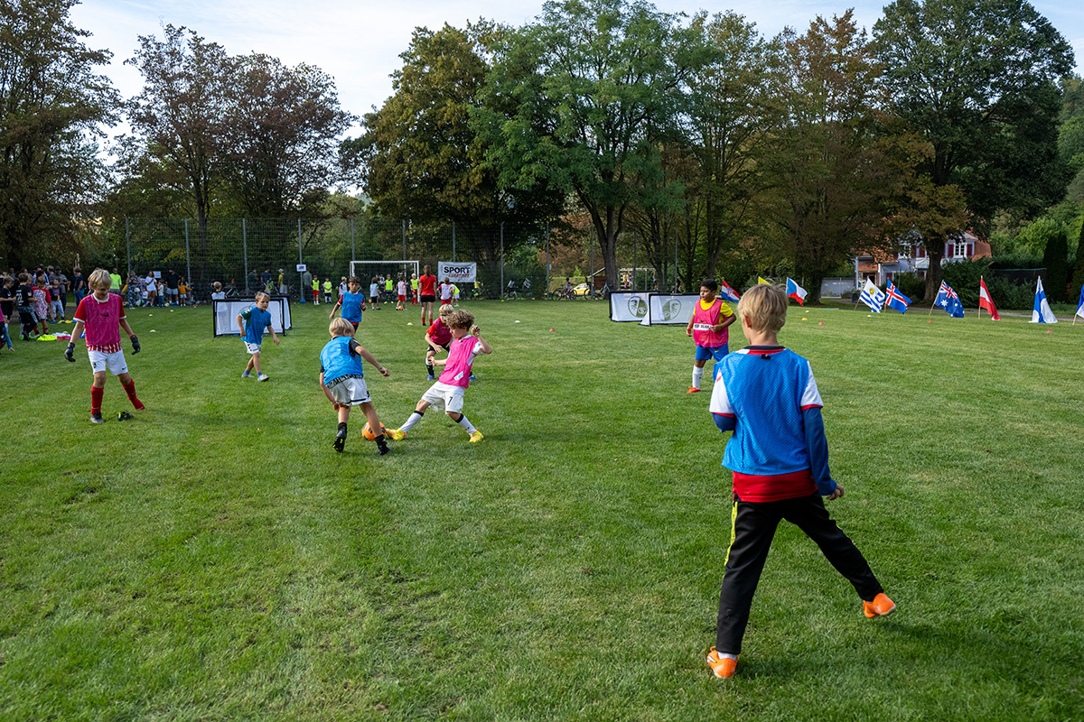 Kinder kicken auf einem Bolzplatz