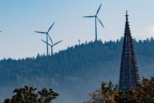 Münsterturm vor Berg mit Windrädern