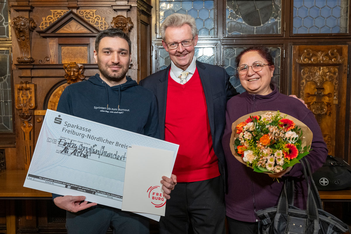 Ali Alsbih mit einem Spendencheck, neben ihm Ulrich von Kirchbach und Pflegerin Zoufinar Murad