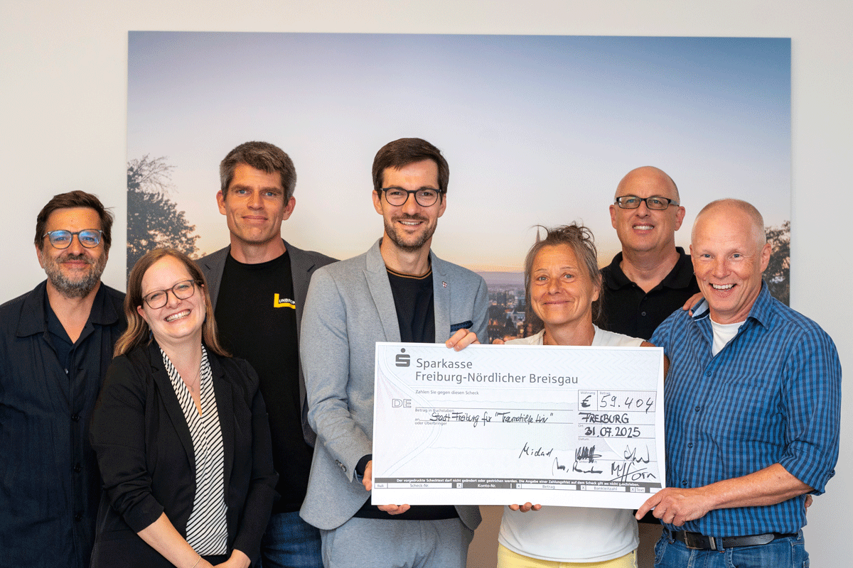 Mehrere Personen halten einen Scheck in der Hand