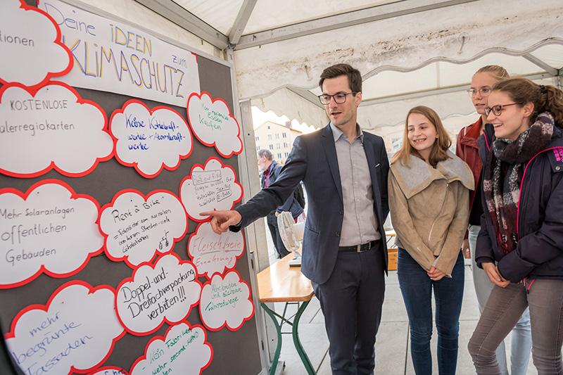 Oberbürgermeister Martin Horn zeigt beim Mitmach-Markt "Klimaschutz" auf Dinge