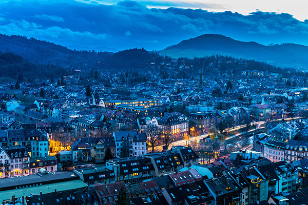 Blick auf die beleuchtete Stadt im Dämmerlicht