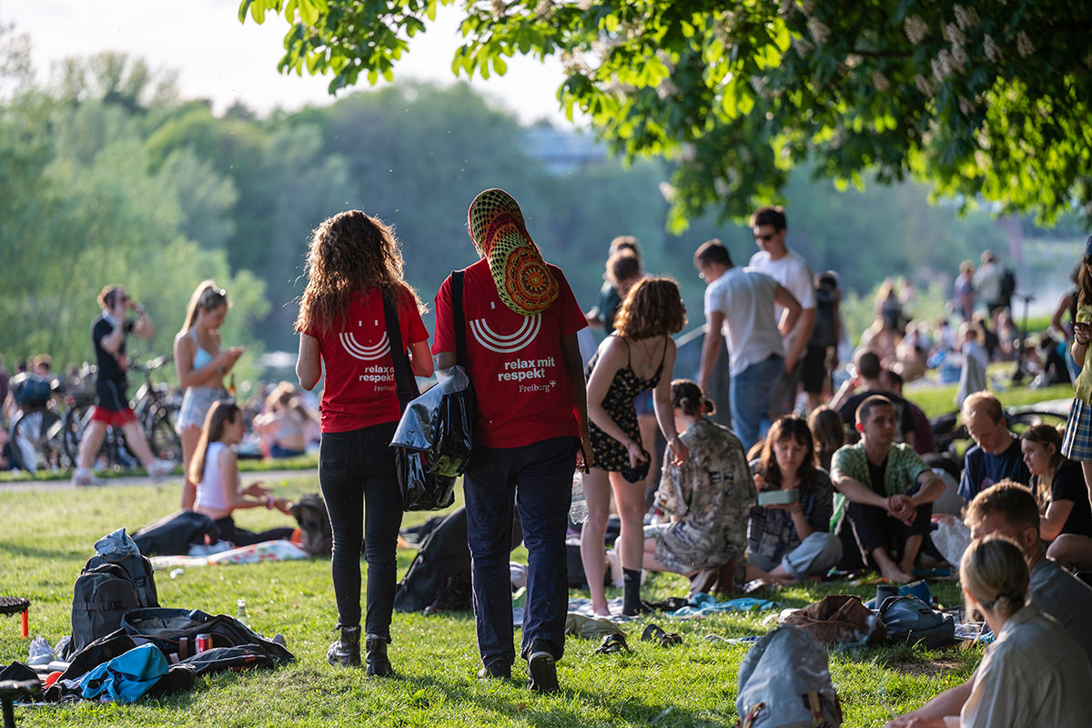 2 Nachmediator_innen von hinten in einer Menge Menschen im Seepark