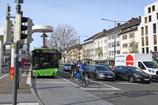 Straße mit Bus, Fahrrädern, Autos