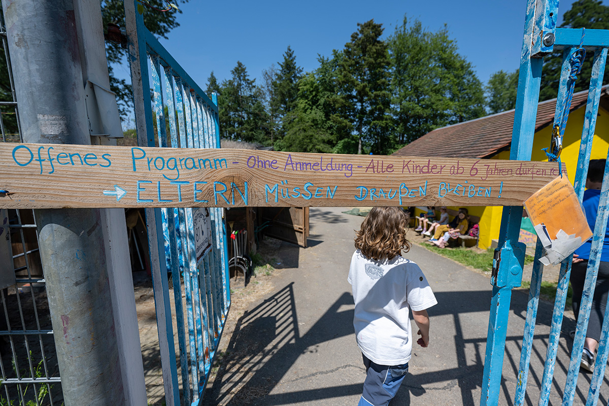 Eingangstor mit Aufschrift "Offenes Programm - ohne Anmeldung - alle Kinder ab 6 Jahren dürfen rein - Eltern müssen draußen bleiben!"