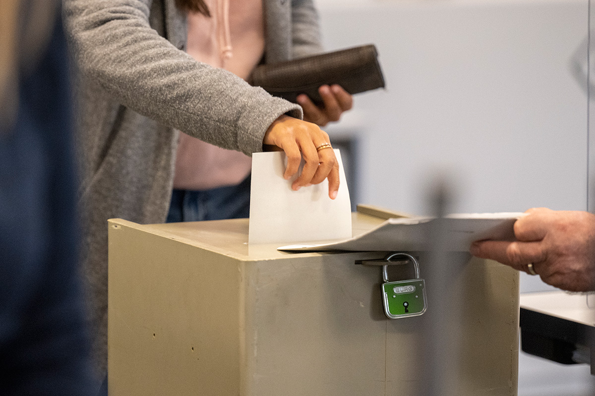 Ein Mann steckt seine Wahlunterlagen in eine Wahlurne
