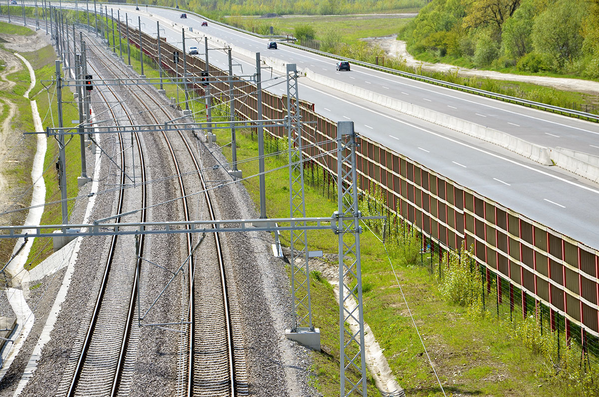 Bahnstrecke entlang einer vierspurigen Straße