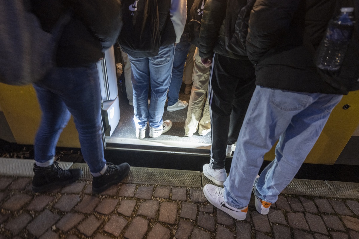 Dicht gedrängte Beine in und vor der S-Bahn. Einige stehen noch am Bahnsteig und warten darauf, einzusteigen.