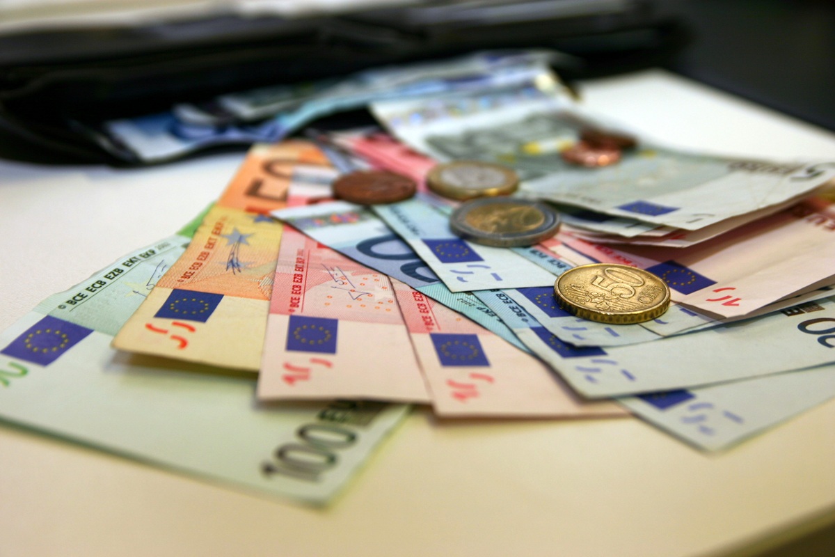 Geldscheine und Münzen liegen auf einem Tisch verteilt.