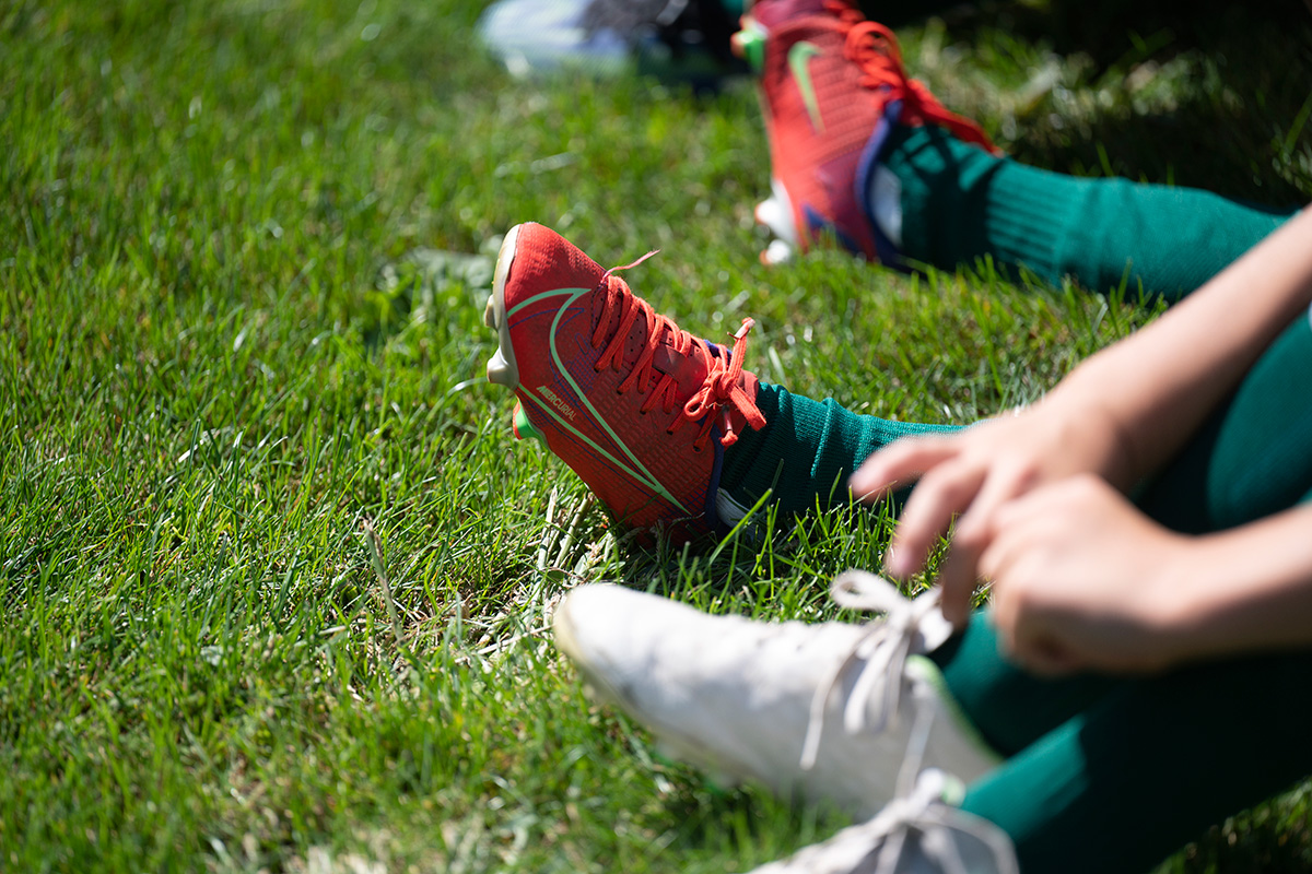 Füße in Fußballschuhen auf einem Bolzplatz