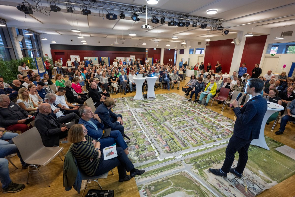 Großer Saal mit Publikum bei einer Veranstaltung, die um den Redner drum herum sitzen (Foto: Stadt Freiburg)